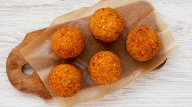 Arancini.  In Italy, Sicilians prepare a coffee snack from cooked rice, mixed with cheese or minced meat, coated in breadcrumbs and fried.  (SHUTTER STOCK)