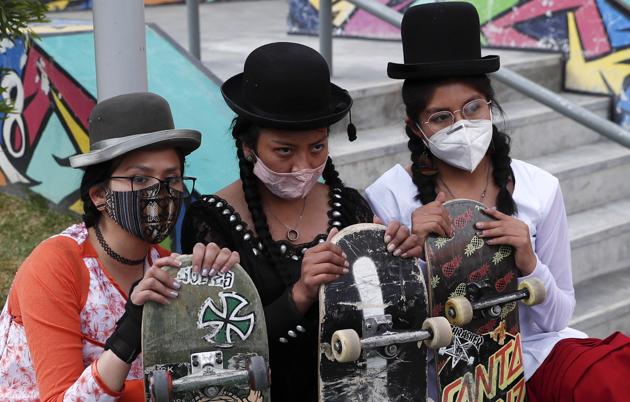 Yanira Villarreal, left, Ayde Choque, center, and Milenda Limachi, wearings masks amid the COVID-19 pandemic and dressed as a "Cholita" pose for a photo with their skateboards during a youth talent show in La Paz, Bolivia, Wednesday, Sept. 30, 2020. (AP)
