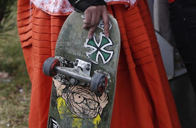 Yanira Villarreal, dressed as a "Cholita" holds her skateboard during a youth talent show in La Paz, Bolivia, Wednesday, Sept. 30, 2020. (AP)