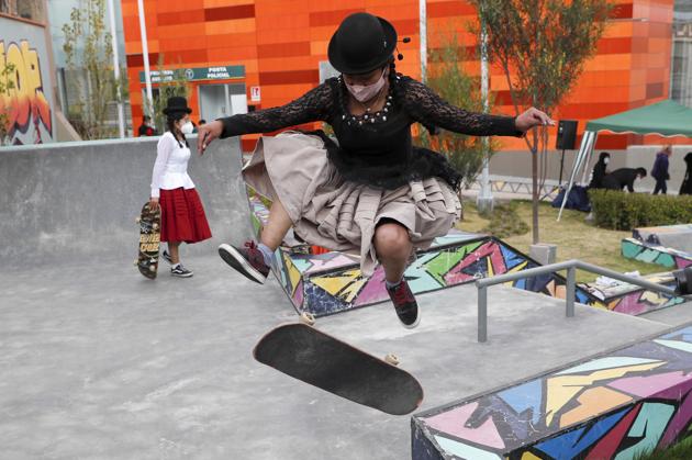 Aide Choque, wearing a mask amid the COVID-19 pandemic and dressed as a "Cholita" jumps with her skateboard during a youth talent show in La Paz, Bolivia, Wednesday, Sept. 30, 2020. (AP)