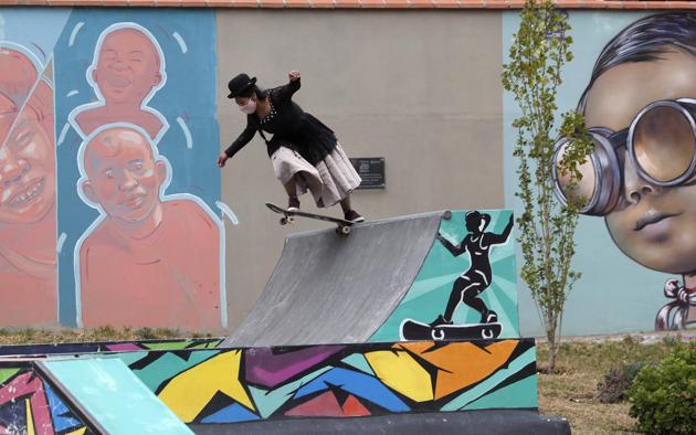 Aide Choque, wearing a mask amid the COVID-19 pandemic and dressed as a "Cholita" rides a skateboard during a youth talent show in La Paz, Bolivia, Wednesday, Sept. 30, 2020. (AP)
