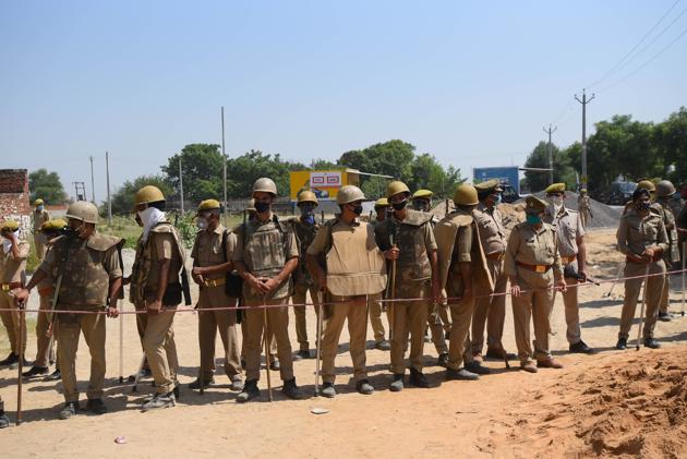 Uttar Pradesh police personnel stand guard at the entrance to a village in Uttar Pradesh’s Hathras. (Amal KS/HT Photo) Uttar Pradesh police personnel stand guard at the entrance to a village in Uttar Pradesh’s Hathras. (Amal KS/HT Photo)