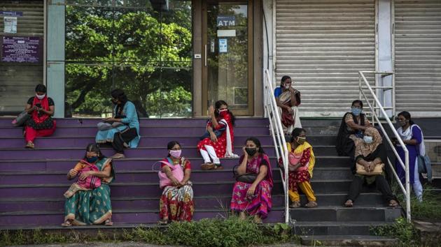 Women who arrived for work await information after the Cochin Special Economic Zone was closed as part of COVID-19 containment measures in Kochi on October 1. India has become the third country in the world to cross this grim landmark. Only the United States with 212,000 deaths and Brazil with 144,000 deaths due to Covid-19 fare worse. (R S Iyer / AP)