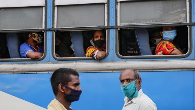 Commuters wearing face masks to prevent coronavirus wait inside a bus as pedestrians walk past at a bus terminus in Kolkata, India, Thursday, Oct. 1, 2020. India is expected to become the pandemic's worst-hit country within weeks, surpassing the United States. (AP Photo/Bikas Das)(AP)