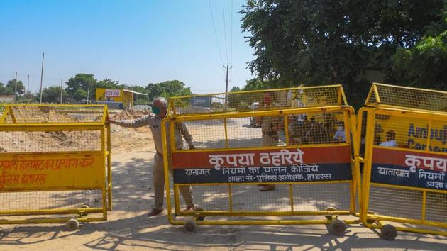 A state police personnel sets up barricades at the entrance to Hathras village in Uttar Pradesh. (Amal KS/ Hindustan Times) A state police personnel sets up barricades at the entrance to Hathras village in Uttar Pradesh. (Amal KS/ Hindustan Times)
