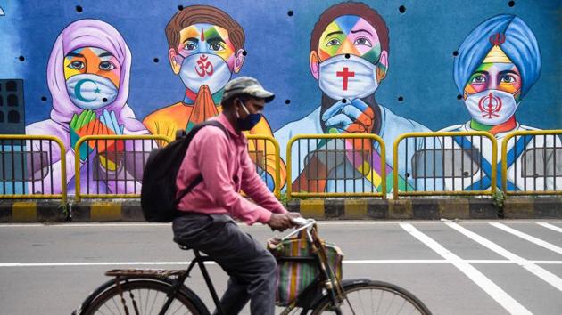 A man cycles past wall art on Covid-19 near Phugewadi in Pune on October 3. The national recovery rate from Covid-19 currently stands at 84.13 %. 75,829 people tested positive for the infection in the previous 24 hours, while the death toll climbed to 1,01,782 with the virus claiming 940 lives in the same period, the data showed. (Sanket Wankhede / HT Photo)