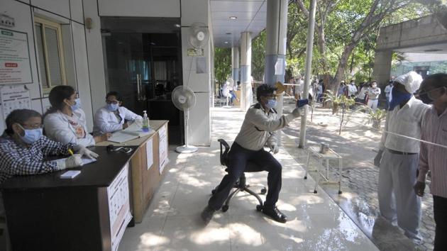 A worker thermal scans people before registration for coronavirus testing, at a district hospital in Noida on October 03. India’s Covid-19 tally had crossed the 2 million mark on August 7, and doubled to 4 million on September 5. Covid-19 cases in the country breached 6 million on September 28. (Sunil Ghosh / HT Photo)