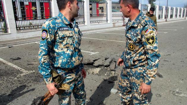 Servicemen of Armenia's Emergencies Ministry stand outside the ministry's building which is said was damaged by Azeri shelling in the breakaway Nagorny Karabakh's main city of Stepanakert on October 2, 2020, during the ongoing fighting between Armenia and Azerbaijan over the disputed region.(AFP) Servicemen of Armenia's Emergencies Ministry stand outside the ministry's building which is said was damaged by Azeri shelling in the breakaway Nagorny Karabakh's main city of Stepanakert on October 2, 2020, during the ongoing fighting between Armenia and Azerbaijan over the disputed region.(AFP)