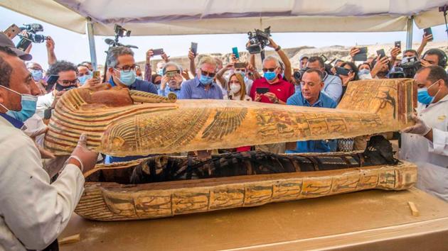 Egyptian Minister of Tourism and Antiquities Khaled Al-Anani (3L), and Mustafa Waziri (2R), Secretary General of the Supreme Council of Antiquities, open a sarcophagus covered in hieroglyphics at the Saqqara necropolis on October 3. (Khaled Desouki / AFP)