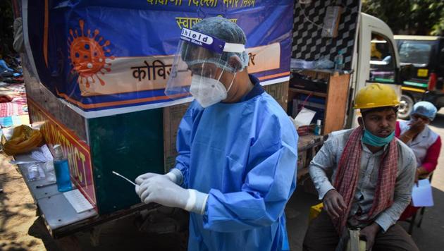 A health worker in PPE coveralls readies to collect a swab sample from a boy for coronavirus testing, at Savitri Nagar, in New Delhi (Photo by Sanchit Khanna/ Hindustan Times) A health worker in PPE coveralls readies to collect a swab sample from a boy for coronavirus testing, at Savitri Nagar, in New Delhi (Photo by Sanchit Khanna/ Hindustan Times)