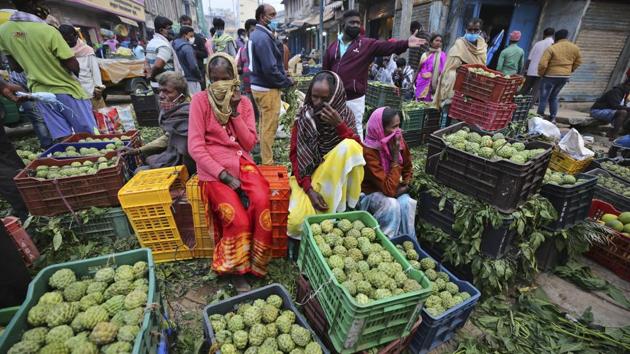 Fruit vendors wait for buyers at a wholesale market in Bengaluru. For over two dozen crops, MSPs are fixed at fifty percent over cost but that does not necessarily lead to higher farm incomes. This is mostly because government’s procurement at MSP rates is largely restricted to wheat and rice. Remaining crops fetch returns that are dictated by market demands. (Aijaz Rahi / AP)
