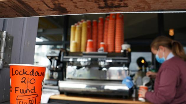 A cup for tips with writing saying 'lockdown 2.0 fund' is seen on a counter top at a coffee shop in Ireland.(REUTERS) A cup for tips with writing saying 'lockdown 2.0 fund' is seen on a counter top at a coffee shop in Ireland.(REUTERS)