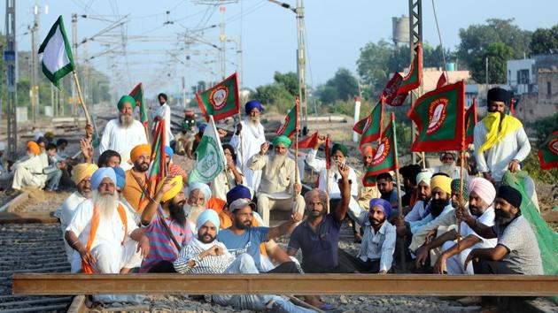 Members of various farmers’ organizations block a railway track in protest against the new reform laws in Patiala district on October 1. Farmers’ groups are protesting against the move to end the monopoly of APMCs, because they fear deregulation will leave them vulnerable to powerful agribusinesses and in an even weaker negotiating position than before. They also fear the reforms may weaken the MSP mechanism. (Bharat Bhushan / HT Photo)