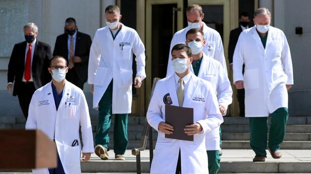 Dr Sean Conley, White House physician (C) arrives with a team of doctors for a press conference outside Walter Reed National Military Medical Center in Bethesda, Maryland on October 4. The last-minute limousine outing came with Trump’s doctors satisfied enough about his progress to suggest the possibility of his being discharged on October 5, AFP reported. (Michael Reynolds / Bloomberg)