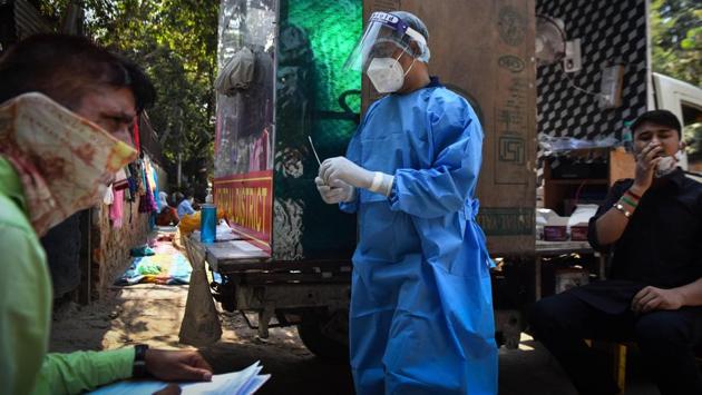 A health worker (centre) readies to collect a swab sample for coronavirus testing in New Delhi on October 4. There were 82,208 recoveries made from infection in the last 24 hours in the country. New recoveries have been exceeding new cases in recent days, and India’s total recoveries stand at 5,744,693 as of October 7. The recovery rate is currently pegged at 84.7%. (Sanchit Khanna / HT Photo)