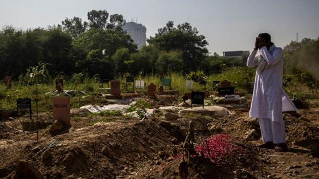 A man prays next to the grave of a relative, who died due to Covid-19, at a graveyard in New Delhi on October 6. The number of deaths due to the coronavirus disease across also dipped to the lowest in a week on October 5 with 884 fatalities being recorded during the period. Deaths from Covid-19 in the country currently stand at 1,04,555. (Danish Siddiqui / REUTERS)