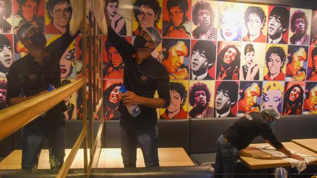 Workers sanitize the premises of a restaurant ahead of its reopening at Lower Parel in Mumbai on October 3. The directorate of tourism department in Maharashtra issued extensive guidelines on October 3 for reopening that included pre-booking of seats, Covid-19 hygiene while serving food, seating arrangements, table etiquette, hospitality norms, entry-exit and washroom hygiene, norms for regular ventilation of premises and disinfection routines, digital or disposable paper menus etc., HT reported. (Pratik Chorge / HT Photo)