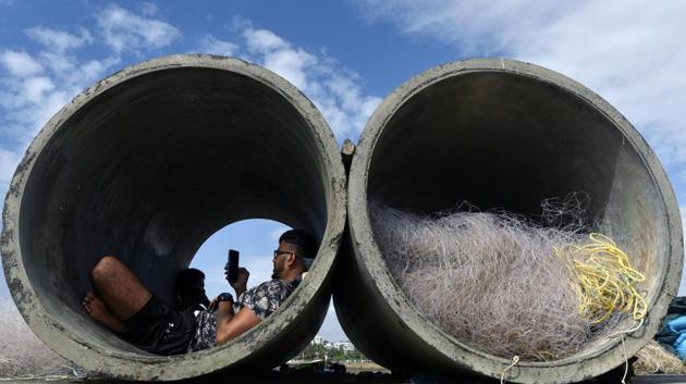 A man uses his phone while sitting inside a cement pipe at Khar danda in Mumbai on, September 27. On the same day as the eateries reopened, Maharashtra also reported 10,244 Covid-19 infections, its lowest spike in 49 days, according to HT’s report. (Satyabrata Tripathy / HT Photo)