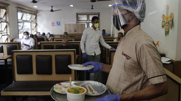 A server wears a face-shield while carrying orders at Liberty Hotel in Mumbai on October 5. Hotels, food courts, restaurants and bars in Maharashtra resumed services on October 5, after a gap of nearly six months in the wake of coronavirus pandemic. (Anshuman Poyrekar / HT Photo)