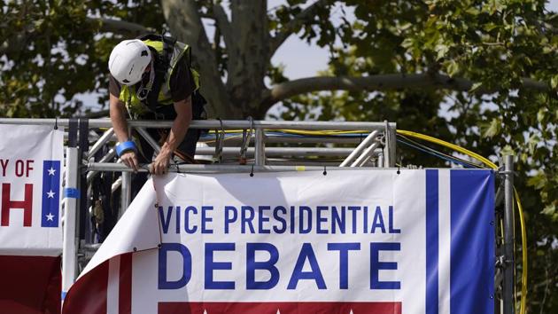 A worker hangs a banner as preparations take place for the vice presidential debate outside Kingsbury Hall at the University of Utah. (AP Photo) A worker hangs a banner as preparations take place for the vice presidential debate outside Kingsbury Hall at the University of Utah. (AP Photo)