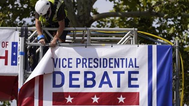A worker hangs a banner as preparations take place for the vice presidential debate outside Kingsbury Hall at the University of Utah. (AP) A worker hangs a banner as preparations take place for the vice presidential debate outside Kingsbury Hall at the University of Utah. (AP)