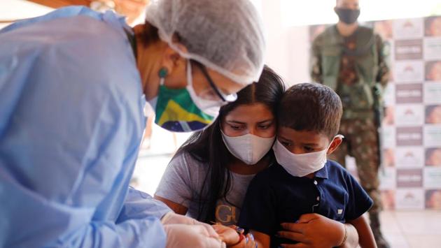 A member of the Brazilian Armed Forces medical team examines a child from the Guajajara indigenous group for Covid-19, at a community school in the village of Morro Branco, Brazil on October 4. The Brazilian military wrapped up on October 5 a three-week operation providing medical care to the Guajajara tribe, in response to criticism that Brazil was not protecting vulnerable indigenous people from the pandemic. (Adriano Machado / REUTERS)