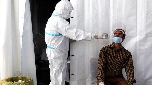 A healthcare worker wearing personal protective equipment (PPE) collects a swab sample from a man on a platform of a railway station, amidst the spread of the coronavirus disease (Covid-19), in New Delhi, India, October 5, 2020.(Reuters photo)