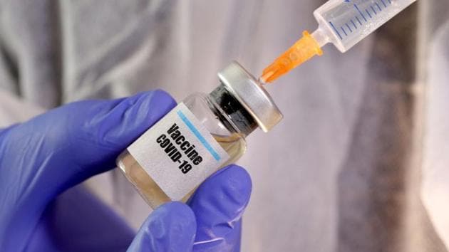 FILE PHOTO: A woman holds a small bottle labeled with a "Vaccine COVID-19" sticker and a medical syringe in this illustration taken April 10, 2020.(REUTERS)