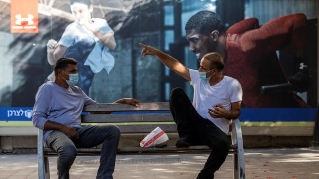Men wearing protective face masks chat on a bench near shuttered shops amid Israel's second national coronavirus disease lockdown in Ashkelon, Israel. (REUTERS) Men wearing protective face masks chat on a bench near shuttered shops amid Israel's second national coronavirus disease lockdown in Ashkelon, Israel. (REUTERS)
