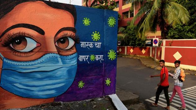 People walk past artwork raising awareness about the use of face masks in Navi Mumbai on October 7. The seven-day average of daily cases in India touched 93,617 on September 16, the highest till date. In the three weeks since, this number (also referred to as the daily case trajectory) has dropped every single day and stands at xxxx on October 8. (Bachchan Kumar / HT Photo)