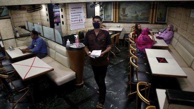 A waiter walks past tables that have been blocked to maintain social distancing at restaurant after they reopened, in Mumbai on October 8. India’s doubling rate — the number of days it takes for the number of infections to double — has seen a drastic improvement in the past month. On October 7, it stood at 60 days, as against 32.6 days on September 7. (Francis Mascarenhas / REUTERS)