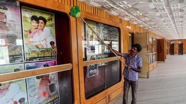 A worker cleans a cinema hall as part of preparations for a possible reopening in Chennai on October 8. Across the world, there have been fluctuations and waves in the case (and death) trajectories — the US, for instance, is on its third wave currently — but India’s trajectory has been climbing till mid-September. (Arun Sankar / AFP)