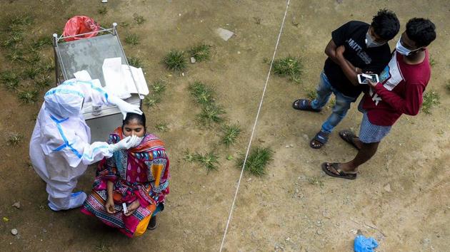 A health worker (L) collects a swab sample from a woman to test for the Covid-19 at a community health centre on the outskirts of Hyderabad on October 7. The first wave of the coronavirus disease (Covid-19) appears to be receding for the first time across the country HT reported, with cases seeing a steady drop for three consecutive weeks. (Noah Seelam / AFP)