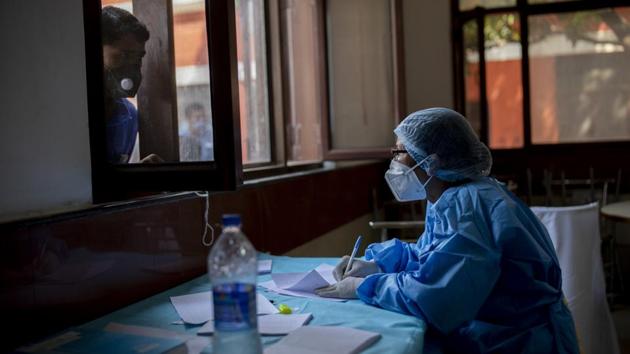 A health worker notes down the name of a person before he is tested for Covid-19 in New Delhi on October 8. A drop has also been seen in the death trajectory. The seven-day average of daily deaths in the country was at its highest on September 15, when it touched 1,169. This number has also dropped since then, and as on October 8, it stands at xxx. (Altaf Qadri / AP)
