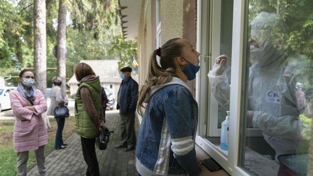 A medical worker collects a sample for Covid-19 testing from a woman outside a hospital. (Representational image) (AP) A medical worker collects a sample for Covid-19 testing from a woman outside a hospital. (Representational image) (AP)