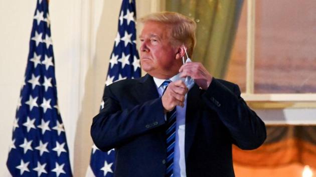 President Donald Trump pulls off his protective face mask as he poses atop the Truman Balcony of the White House after returning from being hospitalized at Walter Reed Medical Center. (REUTERS) President Donald Trump pulls off his protective face mask as he poses atop the Truman Balcony of the White House after returning from being hospitalized at Walter Reed Medical Center. (REUTERS)