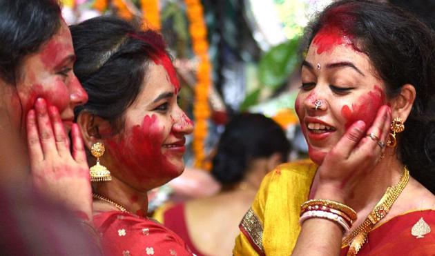 Women smearing each other with vermillion is a common sight during the sindur khela on Vijayadashami, that is the last day of Durga Puja. This year, this celebrations won’t take place at most pandals in Delhi-NCR.(Photo: Arvind Yadav/HT)