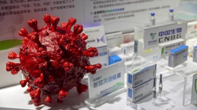 A model of a coronavirus is displayed next to boxes for COVID-19 vaccines at an exhibit by Chinese pharmaceutical firm Sinopharm at the China International Fair for Trade in Services in Beijing on September 5.(AP file)