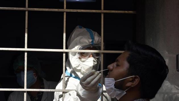 A health worker collects a swab sample from a man to test for coronavirus infection, at SDM office in Amar Colony in New Delhi on Saturday, October 10, 2020. (Sanjeev Verma/HT PHOTO) A health worker collects a swab sample from a man to test for coronavirus infection, at SDM office in Amar Colony in New Delhi on Saturday, October 10, 2020. (Sanjeev Verma/HT PHOTO)