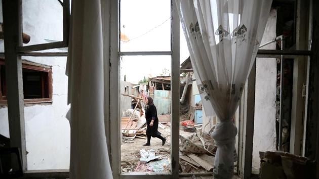 A woman walks past a house damaged by recent shelling during a military conflict over the breakaway region of Nagorno-Karabakh, in the city of Ganja, Azerbaijan.(REUTERS) A woman walks past a house damaged by recent shelling during a military conflict over the breakaway region of Nagorno-Karabakh, in the city of Ganja, Azerbaijan.(REUTERS)