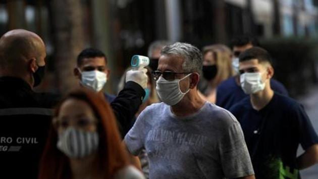 A man wearing a protective face mask has his temperature checked before entering Nova America shopping mall, as malls reopen amid the coronavirus disease (Covid-19) outbreak, in Rio de Janeiro, Brazil.(Reuters) A man wearing a protective face mask has his temperature checked before entering Nova America shopping mall, as malls reopen amid the coronavirus disease (Covid-19) outbreak, in Rio de Janeiro, Brazil.(Reuters)
