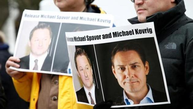 People hold signs calling for China to release Canadian detainees Michael Spavor and Michael Kovrig.(Reuters)