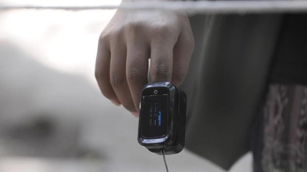 An oximeter is used to examine the blood saturation levels of a person at District Hospital in Sector 30, Noida on October 7. The latest million infections have come in 13 days, compared to the previous million cases coming in 12 days –a statistic that highlights how new cases in the country are relenting. (Sunil Ghosh / HT Photo) An oximeter is used to examine the blood saturation levels of a person at District Hospital in Sector 30, Noida on October 7. The latest million infections have come in 13 days, compared to the previous million cases coming in 12 days –a statistic that highlights how new cases in the country are relenting. (Sunil Ghosh / HT Photo)