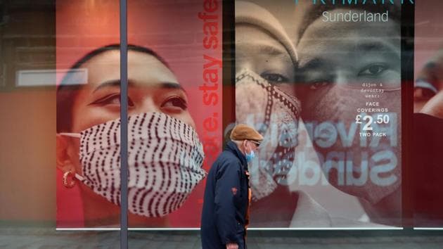A man wearing a face mask walks in Sunderland, Britain.(Reuters)