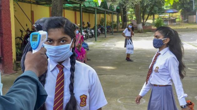 A student undergoes thermal screening before she enters the school in Ranchi. (PTI) A student undergoes thermal screening before she enters the school in Ranchi. (PTI)