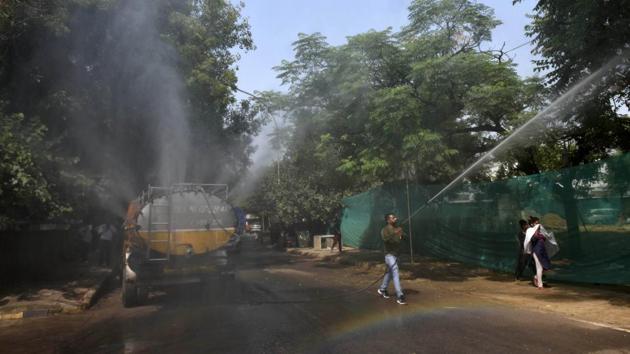 A worker sprays water at a demolition site to control air-pollution, at GPRA Sewa Sadan Netaji Nagar in New Delhi on October 11. The action plan includes a separate strategy for dust control, management of 13 pollution hot spots, a war room for real-time monitoring of pollution levels and efficacy of measures to fight pollution, and a mobile app for registering complaints. (Vipin Kumar / HT Photo)