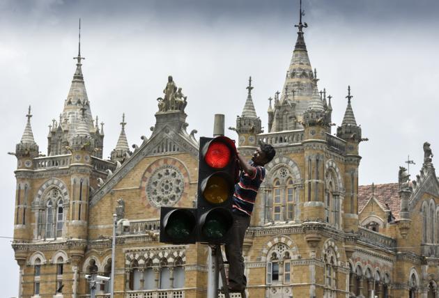 Mumbai, India - July 3, 2017:A worker cleans traffic signal at CST in Mumbai, India, on Monday, July 3, 2017. (Photo by Kunal Patil/Hindustan Times) (Kunal Patil/HT Photo) Mumbai, India - July 3, 2017:A worker cleans traffic signal at CST in Mumbai, India, on Monday, July 3, 2017. (Photo by Kunal Patil/Hindustan Times) (Kunal Patil/HT Photo)