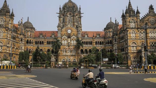 Commuters ride past the Chatrapati Shivaji Terminus (CST) railway station in Mumbai on October 12. India’s financial capital saw its massive power outage because of a grid failure, disrupting transport networks, delaying exams and affecting civic health services. (Dhiraj Singh / Bloomberg)