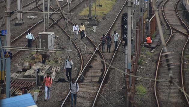 Commuters take to walking on railway tracks after trains were stranded due to the disruption, at Mumbai Central in Mumbai on October 12. While the outage caused disruption in local services, no outstation train was stranded. Meanwhile, with signals and CCTV cameras ceasing to function, traffic police personnel faced difficulties in manning the traffic. (Bhushan Koyande/ HT Photo)