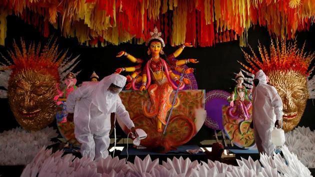 People wearing personal protective equipment (PPE) sanitise a ‘pandal’ or a temporary platform next to an idol of Goddess Durga ahead of the annual festival, amidst the coronavirus pandemic in Kolkata on Monday. (REUTERS PHOTO.) People wearing personal protective equipment (PPE) sanitise a ‘pandal’ or a temporary platform next to an idol of Goddess Durga ahead of the annual festival, amidst the coronavirus pandemic in Kolkata on Monday. (REUTERS PHOTO.)